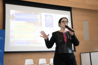 woman holding a microphone and speaking in front of a group